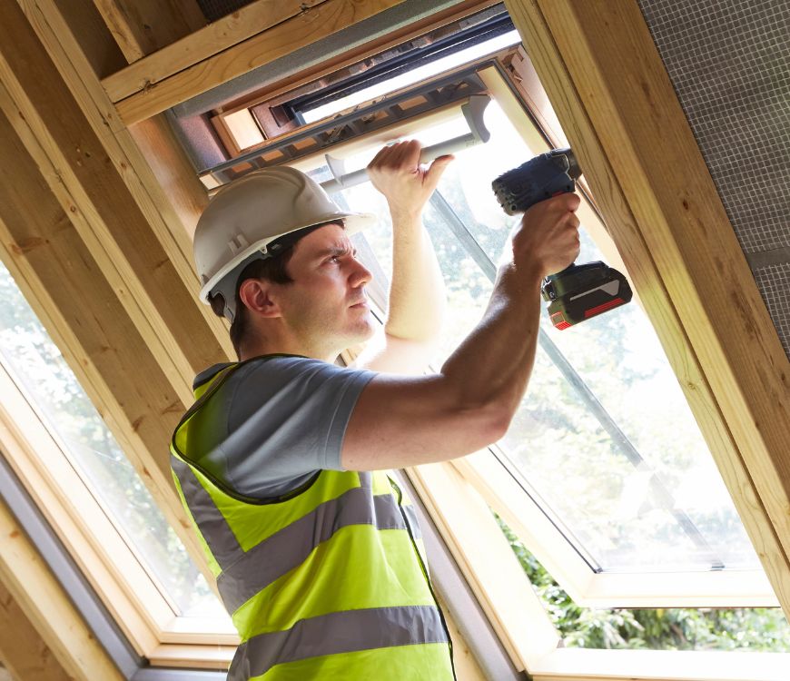 Contractor in West Valley City, UT installing a window with an electric drill