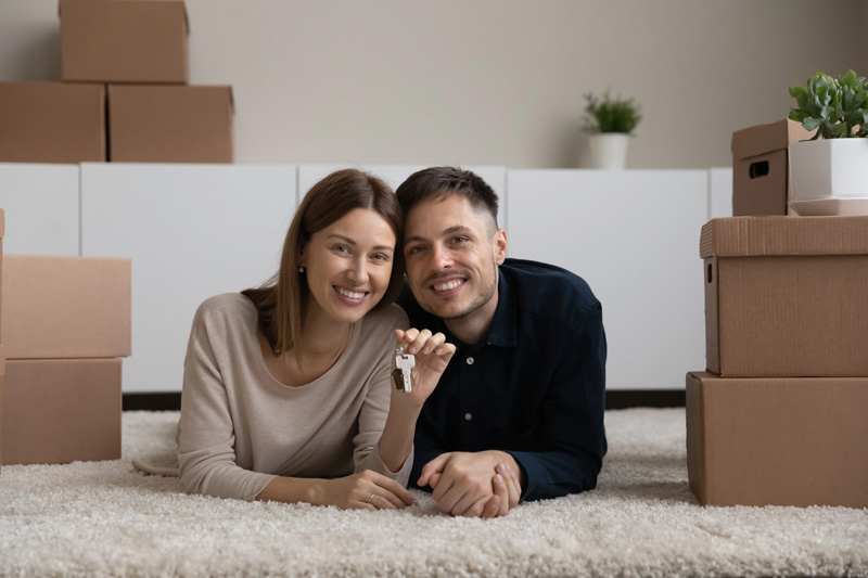 couple smiling holding keys in their rental unit with Renters & Landlord Insurance in Salt Lake City, Murray, Riverton, Sandy, West Valley City, UT