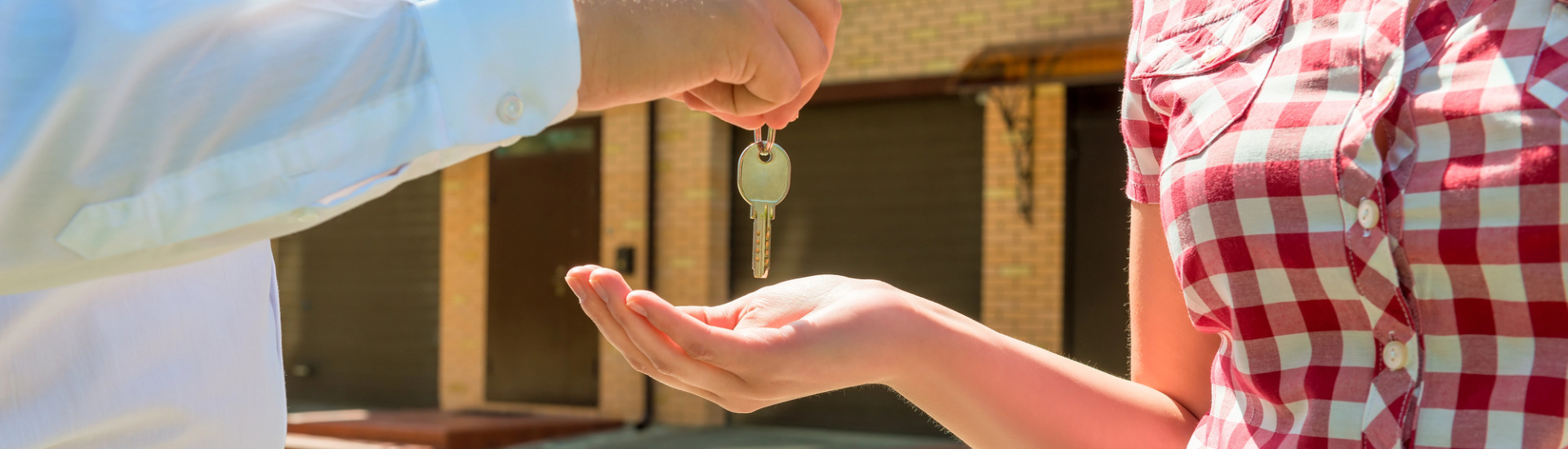 Landlord handing a renter a set of keys to a new rental unit