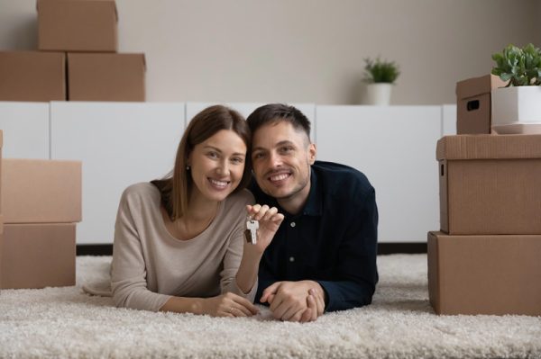couple smiling holding keys in their rental unit with Renters & Landlord Insurance in Sandy, UT